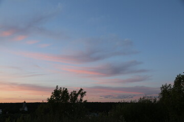 Beautiful sunset sky and tree silhouette under bright colorful clouds from the high. Yellow orange nature background in the evening time at summer season, no people. Natural real colors, untouched