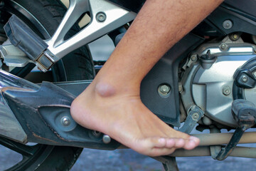Fototapeta premium close up of a man's foot pedaling a motorbike to start it
