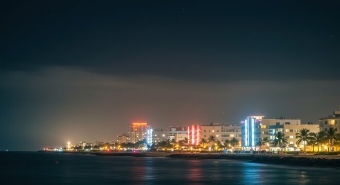 Vibrant coastal city lights illuminate the tranquil ocean under the night sky Miami Beach