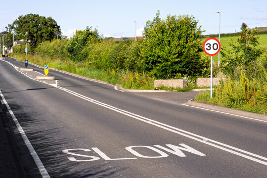 Rural Road with SLOW Marking, No Overtaking Lines and 30mph Speed Limit Sign