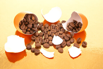 A broken egg with coffee beans spilling out on a golden surface, surrounded by scattered eggshells, creating a surreal and creative composition for food and beverage themes
