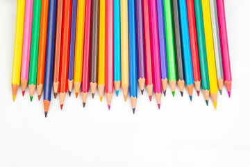 A vibrant row of sharpened colored pencils in various hues against a white background. Perfect for art supplies, creativity, and back-to-school themes.