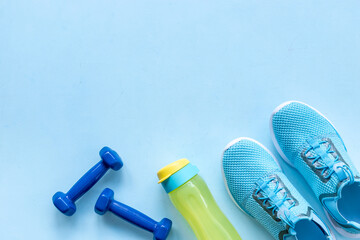 Top view of gym sports equipment with sneakers and dumbbells. Wellness concept