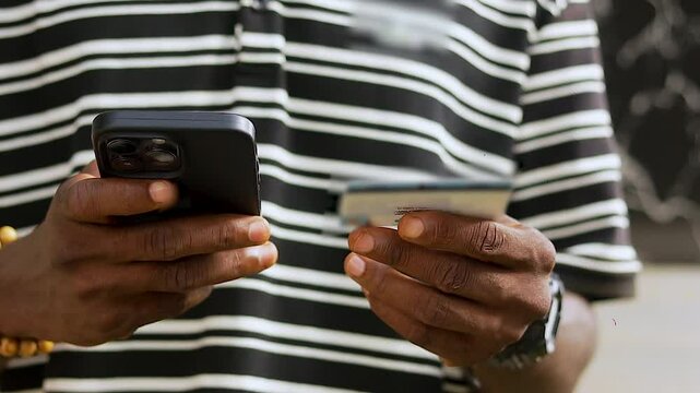 close up shot of hand holding mobile phone and credit card