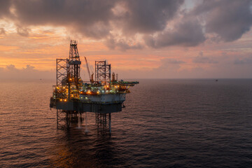 Aerial view of offshore jack up drilling rig during sunset - oil and gas industry