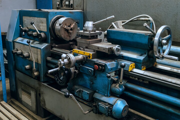 Old blue lathe. Metalworking machine close-up. Lathe handles.