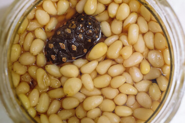 Pine jam made from young cones with pine nuts in glass jar. Top view. Siberian sweet treat.