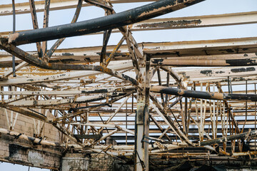 Thermal deformation. Damaged by fire metal roof structures in steel frame.