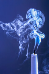 Smoke from an extinguished candle on a dark background. The concept of spirituality and the end of...