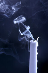 Smoke from an extinguished candle on a dark background. The concept of spirituality and the end of...