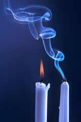 Smoke from an extinguished candle on a dark background. The concept of spirituality and the end of...