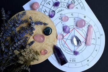 Beautiful crystals of amethyst and rose quartz and dried lavender herbs with symbols of the zodiac...