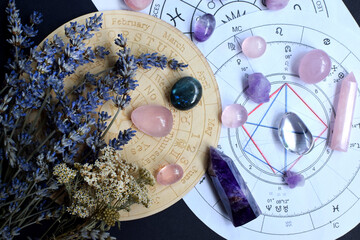 Beautiful crystals of amethyst and rose quartz and dried lavender herbs with symbols of the zodiac...