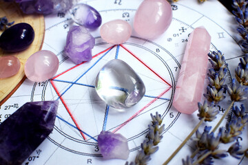 Beautiful crystals of amethyst and rose quartz and dried lavender herbs with symbols of the zodiac...
