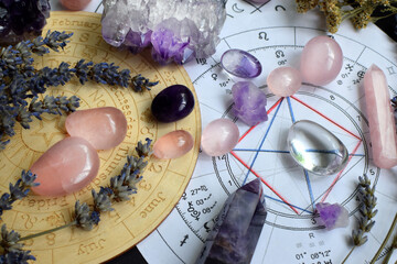 Beautiful crystals of amethyst and rose quartz and dried lavender herbs with symbols of the zodiac...