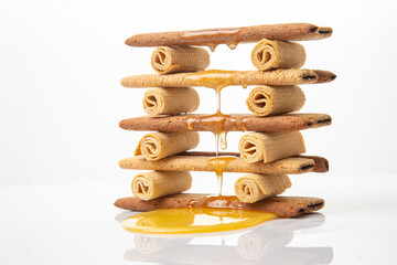 Fresh flower honey flows and drips onto herdry crispy cookie sticks. Dessert snack food.