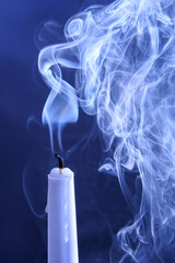 Smoke from an extinguished candle on a dark background. The concept of spirituality and the end of...