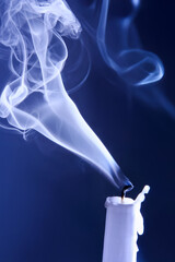 Smoke from an extinguished candle on a dark background. The concept of spirituality and the end of...