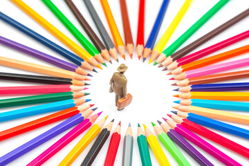 miniature figures is surrounded by a radial arrangement of multicolored pencils, creating a bright...