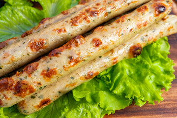 Delicious grilled sausages on a bed of fresh lettuce at a backyard barbecue gathering