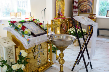 Decorated altar with religious icons and baptismal font in a serene church setting