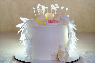 Elegant white cake with intricate decorations for a special celebration in a beautifully lit setting