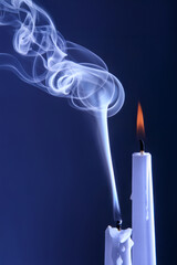 Smoke from an extinguished candle on a dark background. The concept of spirituality and the end of...