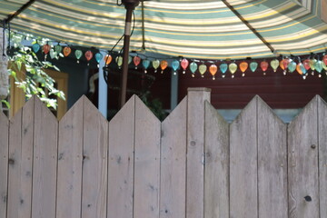 A top of wooden fence with a colored sunshade. Summer time and relaxation. Lifestyle and summer...