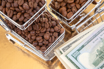 On a golden surface, a cart of roasted coffee beans pairs with $100 bills, highlighting the...