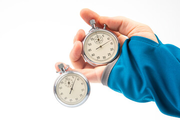 Two mechanical stopwatches hang on the fingers of a male hand. Time part precision. Measurement of...