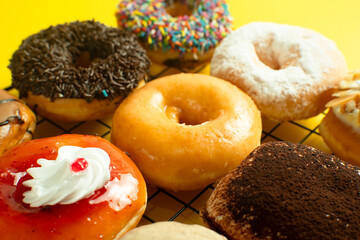 A close-up shot of a variety of donuts on a cooling rack. The donuts are topped with colorful...