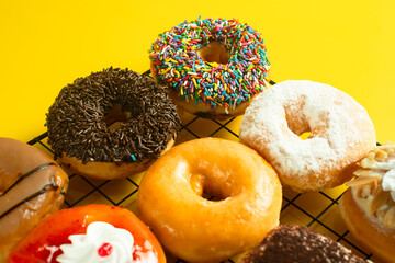 A close-up shot of a variety of donuts on a cooling rack. The donuts are topped with colorful...