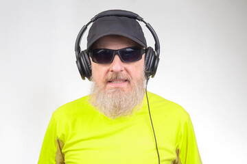 bearded man in sunglasses and headphones listens to music. audio sound style and technology