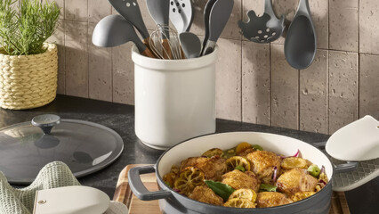 Delicious chicken dish cooked with peppers and lemons in a cozy kitchen setting.