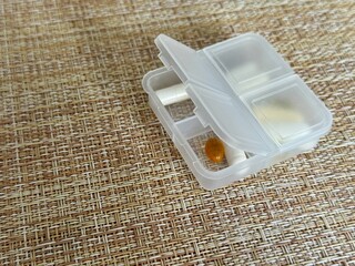 The weekly transparent pillbox is designed for convenient and efficient daily storage of dietary supplements and tablets. It has compartments with various types of capsules for administration.