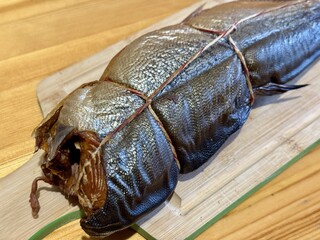 Cold hot smoked mackerel, beautifully laid out on a wooden chopping board, is ready for cooking and...