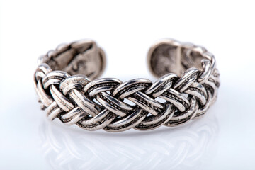 Naklejka premium Intricately designed silver cuff bracelet showcasing detailed weaving patterns against a clean background