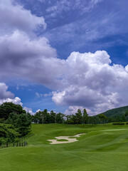 golf course with sand bunker under dramatic summer clouds 
