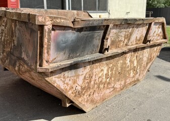 An old rusty dumpster sitting on a bustling city street filled with urban life and debris. The...
