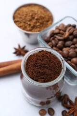 Different types of instant coffee, beans and spices on light table, closeup