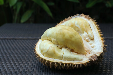 Fresh ripe durian on wicker table outdoors, closeup. Space for text