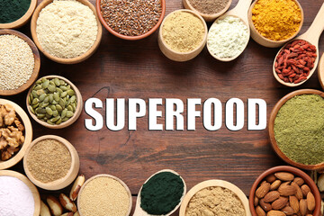 Superfood. Different powders and food products on wooden table, flat lay