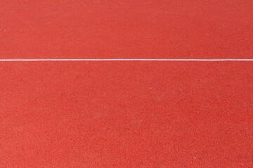 A vibrant red surface designed for athletic activities highlights the area where runners will...