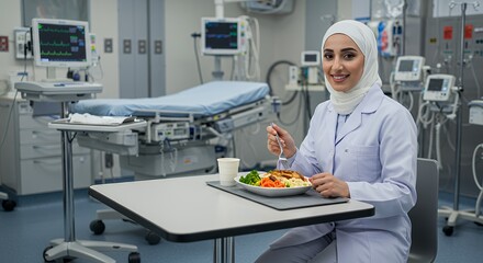 A smiling female doctor in a hijab enjoys a healthy meal during a well-deserved break in a modern hospital setting.
