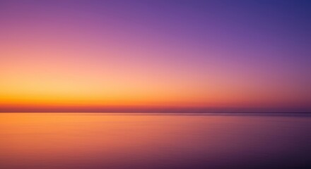 Obraz premium Tranquil ocean at sunset with a gradient sky of orange, pink and purple hues