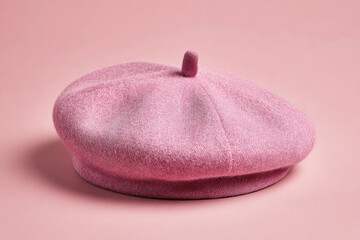 Pink wool beret placed on a soft pink background, showcasing its texture and design for fashion use