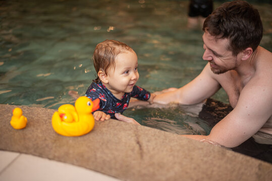 Father and baby son having fun in a kiddie pool