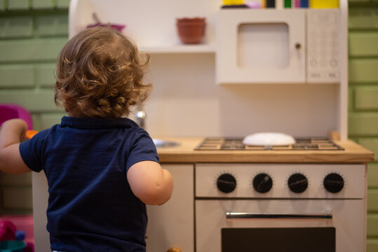 Baby boy playing with a toy kitchen