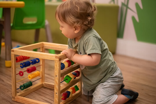 16-month-old baby playing with an abacus - Powered by Adobe