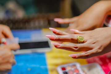 "Nail Technician Working on Client's Manicure in Beauty Salon"

